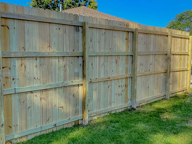 Staining wood fence  after installation in Cedar Valley